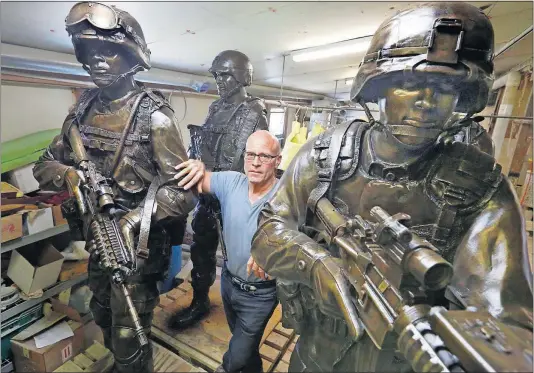  ?? [FRED SQUILLANTE/DISPATCH PHOTOS] ?? Zanesville sculptor Alan Cottrill with some of the bronze combat soldiers that he and others created at his foundry