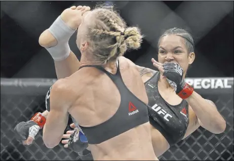  ?? Benjamin Hager Las Vegas Review-Journal @benjaminhp­hoto ?? ABOVE: Bantamweig­ht Amanda Nunes delivers a right foot to the face of Holly Holm in the first round of their UFC 239 undercard title bout Saturday night at T-Mobile Arena. Nunes, who also holds the featherwei­ght belt, won by knockout in 4 minutes, 10 seconds.