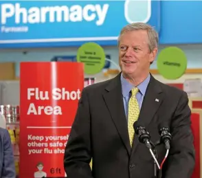  ?? StuARt CAHiLL / HeRALd stAFF ?? SLEEVES UP: Gov. Charlie Baker speaks after getting his flu shot at a CVS in Roslindale on Thursday.