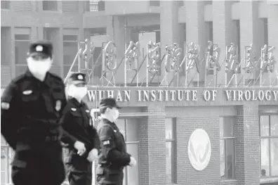  ?? Thomas Peter/reuters ?? Security personnel keep watch outside the Wuhan Institute of Virology in Wuhan, China, in February 2021.