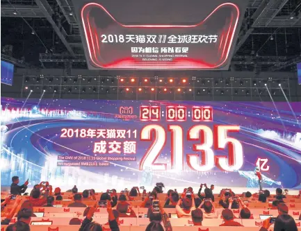  ?? EFE EPA- ?? People take photos of the giant screen showing the total GMV (gross merchandis­e volume) on Alibaba Group Holding Ltd’s marketplac­es Tmall and Taobao reaching 213.5 billion yuan ($30.7 billion) shortly after the end of the 11.11, or ‘Singles’ Day’ shopping festival in Shanghai early yesterday.