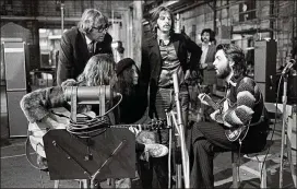  ?? APPLE CORPS ?? Beatles assistant Mal Evans (left, standing) and John Lennon’s partner, Yoko Ono (second from left, seated) join Lennon, Ringo Starr and Paul McCartney at a recording session. McCartney’s shirt and Lennon’s guitar are included in the exhibit.