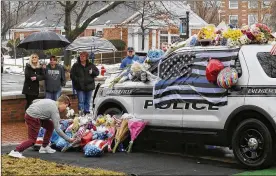  ?? SAM GREENE / THE CINCINNATI ENQUIRER ?? Mourners gather and leave flowers on a police cruiser parked in front of City Hall in Westervill­e on Sunday. Westervill­e police officers Anthony Morelli and Eric Joering were killed in the line of duty Saturday when a suspect opened fire on them as...