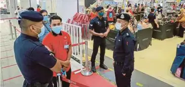  ??  ?? ANGGOTA polis Dang Wangi memantau orang ramai yang membeli-belah bagi persiapan sambutan Aidilfitri di pusat beli-belah Sogo, Kuala Lumpur ketika tinjauan kepatuhan SOP PKP 3.0.