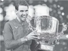  ??  ?? Rafael Nadal of Spain holds the trophy after winning the men’s singles final match against Nick Kyrgios of Australia at the China Open tennis tournament in Beijing. - AFP photo