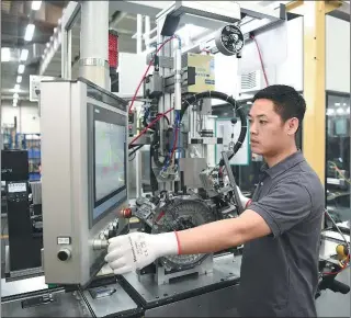  ?? PHOTOS PROVIDED TO CHINA DAILY ?? An employee works on the production line of P2 hybrid module, an innovative solution for electric motors.