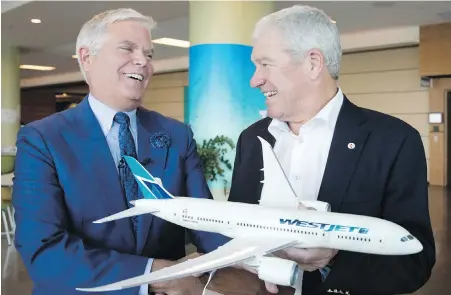  ??  ?? WestJet Airlines president and CEO Gregg Saretsky, left, and board chairman Clive Beddoe hold a model of the Boeing 787 Dreamliner after the purchase of the airplane was announced at the company's annual general meeting in Calgary.