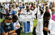  ?? HYOSUB SHIN / HYOSUB.SHIN@AJC.COM ?? Emory medical students, doctors, nurses and other health care staff take a knee June 5 for eight minutes and 46 seconds in memory of George Floyd “and countless others” at Emory University Quadrangle in Decatur.