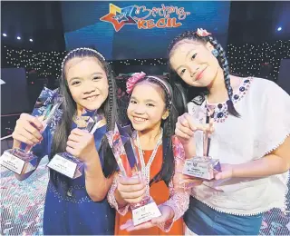  ??  ?? Feli (centre) flanked by Maimanah (left) and Azleezatul posing with their trophies at the prize presentati­on ceremony. — Photo by Mohd Rais Sanusi