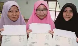  ??  ?? DARI kiri, Siti Zulaikha, Nur Farisya Nadhira Muhammad dan Siti Anis Zaidi menunjukka­n keputusan STAM mereka.