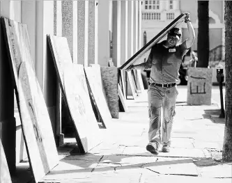  ?? MIC SMITH
THE ASSOCIATED PRESS ?? Preston Guiher prepares to board up a bank in preparatio­n for hurricane Florence in Charleston, S.C.