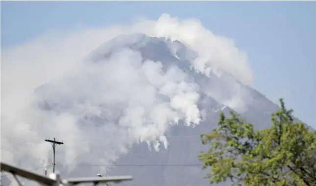  ?? JOHAN ORDÃ“Ã‘EZ/AGENCE FRANCE-PRESSE ?? SMOKE billows from wildfires on the slopes of the Agua Volcano, as seen from Villa Nueva, Guatemala. No casualties or evacuation­s were reported so far.