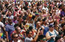  ?? Michael Ciaglo / Houston Chronicle ?? Revelers enjoy a concert on the steps of City Hall during Houston Pride Festival.