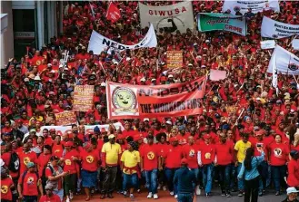  ??  ?? In alto, un giovane lavoratore controlla il motore di un tir nella linea di produzione della Hyundai, a Johannesbu­rg. Sopra, membri della Saftu, South African Federation of Trade Unions, in una marcia di protesta durante gli scioperi dello scorso aprile contro il governo.