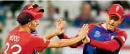  ?? Photo: AFP ?? England captain Eoin Morgan (right) celebrates with teammates after taking a catch to dismiss New Zealand’s Jimmy Neesham.