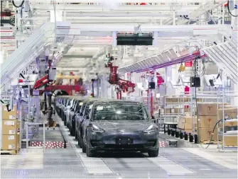  ??  ?? Tesla Model 3s roll through an assembly line at Tesla's factory in Shanghai on Tuesday.