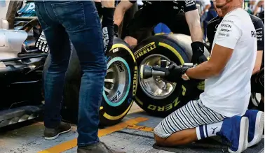  ?? REX ?? Happy to help: world champion Lewis Hamilton lends a hand in the Mercedes pit