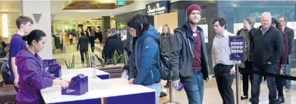  ?? PHOTO: LINDA ROBERTSON ?? Lining up . . . Cadbury employees Ben Epton and Yamta Zubiri hand out free chocolate to Eve Moodie and Book Ruffell at Golden Centre mall yesterday.