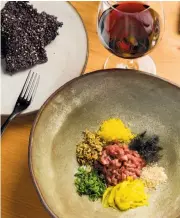  ?? Photos by Jason Henry / Special to The Chronicle ?? Above: Well-seasoned lamb tartare is surrounded by sprouts, seeds, bottarga, fennel fronds and other items. Diners mix it together before eating. Right: Spice-rubbed grilled squab is served with salted chile paste.