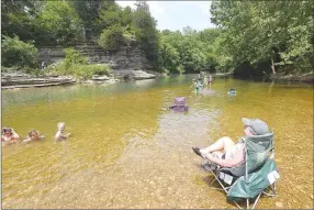  ?? Photos by NWA Democrat-Gazette/Flip Putthoff ?? An adult keeps an eye on young swimmers at the Gar Hole swimming hole on the War Eagle River in southeast Benton County. It’s a popular cooling off spot for people who live in and around Hindsville.