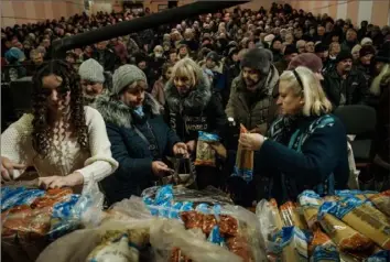  ?? AFP via Getty Images ?? Church members distribute food to local residents after a Mass on Sunday at the Ark of Salvation Church in Kramatorsk, Ukraine.