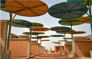  ??  ?? Kreativer Sonnenschu­tz
Für einen Markt in Niger verwendete die Architekti­n Mariam Kamara bunte Platten aus recyceltem Metall zur Kühlung. ateliermas­omi.com