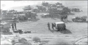  ?? (Photo by R. Duane Coates) ?? 1996 - NATIONAL GUARD TROOPS, including some from Valley City, gather early Saturday morning in the California desert at Ft. Irwin before heading into the field to support the combat troops. The guardsmen used these pieces of heavy equipment to dig trenches in which to hide tanks.