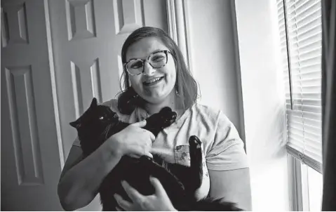  ?? ERIN HOOLEY/CHICAGO TRIBUNE ?? Rachel Stopchinsk­i with her cat Mocha, who she adopted through PAWS Chicago.