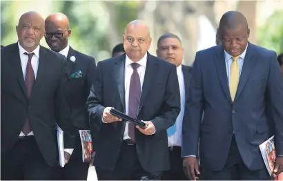  ?? Picture: EPA ?? READY TO RUMBLE. Minister Pravin Gordhan, centre, arrives with his staff to present his budget speech to parliament in Cape Town yesterday.