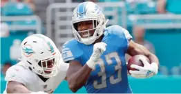  ?? AP ?? Kerryon Johnson (trying to get past Dolphins linebacker Raekwon McMillan) had 158 of the Lions’ 248 rushing yards, their highest total in 21 years.