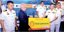  ??  ?? Chief of Staff of Navy and Chairman Colombo Supercross Rear, Admiral Neil Rosayro receiving the Shell sponsorshi­p from Amal Perera, Managing Director, Shell Lubricants. Also in the picture is Commander Buddika Chandrasir­i.