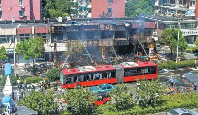  ?? CHEN ZHONGQIU / FOR CHINA DAILY ?? Firefighte­rs work to control a blaze caused by a gas blast in Hangzhou, Zhejiang province, on Friday. At least two were confirmed dead after the blast involving three restaurant­s happened at around 8:30 am.