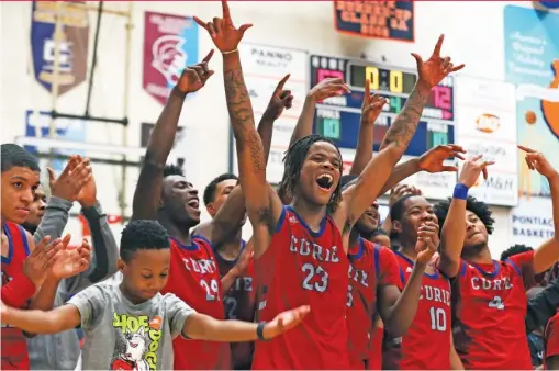  ?? ALLEN CUNNINGHAM/SUN-TIMES ?? Ramean Hinton (23) and the rest of the Curie team celebrate after winning the title at the Pontiac Holiday Tournament in December.