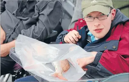  ??  ?? Fresh catch: Steven Dart wraps up some fish to take home after his Reels on Wheels trip.