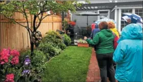  ?? FILE PHOTO ?? Guests look through some of the plants and flowers in a garden featured in the 18th annual Hidden Garden Tour in downtown Troy.