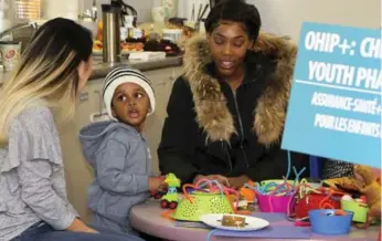  ?? ANDREW FRANCIS WALLACE/TORONTO STAR FILE PHOTO ?? Matian Brand, right, and her son Zion, 2, at a recent event where Health Minister Eric Hoskins announced the minimum wage hike and free prescripti­on plan on more than 4,000 drugs for people 25 and younger.