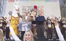  ?? Katie Falkenberg
Los Angeles Times ?? TIMES PUBLISHER Austin Beutner, right, and Dr. C.L. Max Nikias, USC’s president, watch as the Trojan band kicks off the festival.