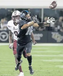  ?? ASSOCIATED PRESS ?? TRYING TO GRAB ANOTHER WIN: Central Florida’s Tre Nixon stretches for the ball in front of Temple’s Ty Mason during last night’s game in Orlando, Fla.