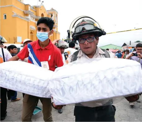  ?? Photo: AFP ?? Volunteer firefighte­rs carry the coffins of two children who were killed by El Fuego volcano in Guatemala.