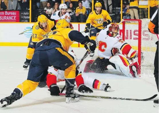  ?? FREDERICK BREEDON/GETTY IMAGES ?? Calgary Flames goaltender David Rittich makes a save on a shot by Nashville Predators left wing Kevin Fiala, at left, during the final moments of Thursday night’s game in Nashville, Tenn. Rittich stopped 29 of 32 shots as the Flames beat the reigning Western Conference champions 4-3 on Thursday.