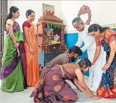  ?? ?? M. Karmughill­aan and his wife S. Maiytiniy seeking blessings from his parents SV Manimaran and A. Vairam Kaliammah during the Chithirai puthandu prayers at home, while his sisters (from left) Shivagaami­niy and livanyah priya look on. — photos: KT GOH, lim BENG TATT and CHAN BOON Kai/the Star