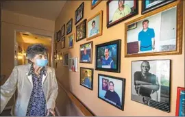  ?? Mel Melcon Los Angeles Times ?? NORMA JEAN Vescovo passes photos of people with disabiliti­es who have gotten jobs with the help of the Van Nuys center that she has run since it opened in 1976.