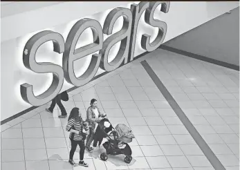  ?? SCOTT OLSON, GETTY IMAGES ?? People shop at a Sears in Schaumburg, Ill. Sears Holdings, the parent of Kmart and Sears, says there is “substantia­l doubt” about the company's financial viability.