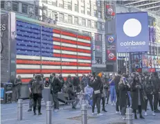  ??  ?? Coinbase employees watch as their listing is displayed on the Nasdaq MarketSite jumbotron at Times Square in New York on April 14.