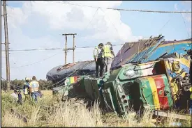  ?? AFP ?? Passenger Rail Agency South Africa inspectors look at a derailed train after an accident took place near Kroonstad, some 110 kilometers south of Johannesbu­rg on Thursday.