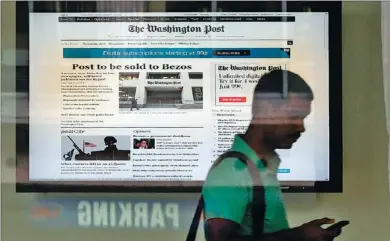  ?? GETTY IMAGES VIA AGENCE FRANCE-PRESSE ?? A man leaves The Washington Post building after the announced sale of the newspaper on Monday in Washington. The Graham family has agreed to sell the flagship newspaper for $250 million to Amazon.com founder Jeffrey Bezos.