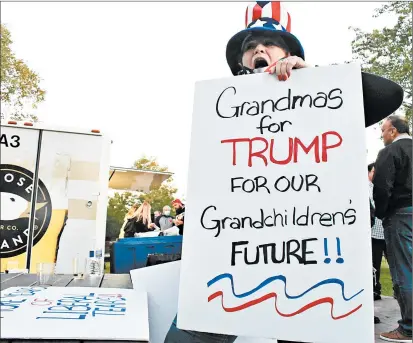  ?? JESSE WRIGHT/DAILY SOUTHTOWN ?? Monica Derry holds up a sign in support of President Donald Trump on Friday at the GOP Jamboree at Konow Farm in Homer Glen.