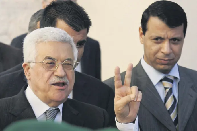  ??  ?? Palestinia­n Authority President Mahmoud Abbas (L) flashes the V sign as then-Fatah official Mohammed Dahlan (R) looks on in the West Bank town of Ramallah, Palestine, Dec. 18, 2006.