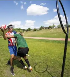  ??  ?? Jonathan Golla, left, is blocked by Spencer Van Milligen while attempting a shot at the hoop. Unlike many games, quidditch is a contact sport.