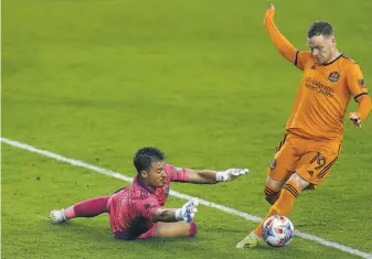  ?? Godofredo A. Va¡squez / Houston Chronicle ?? Earthquake­s goalkeeper JT Marcinkows­ki makes a save against Houston’s Tyler Pasher.